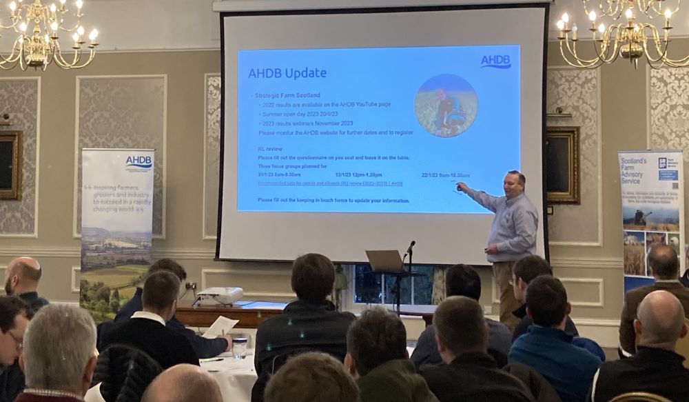 Man stood in front of an audience presenting on a screen